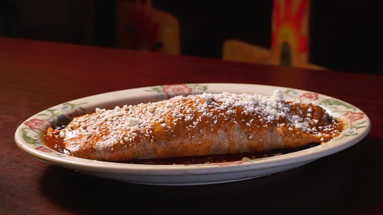 A beautifully plated cannoli filled with rich chocolate cream and topped with crushed pistachios.