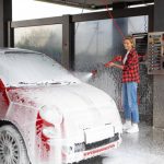 Mobile Car Wash Shrooms Q service in action, showing a professional team cleaning a vehicle.