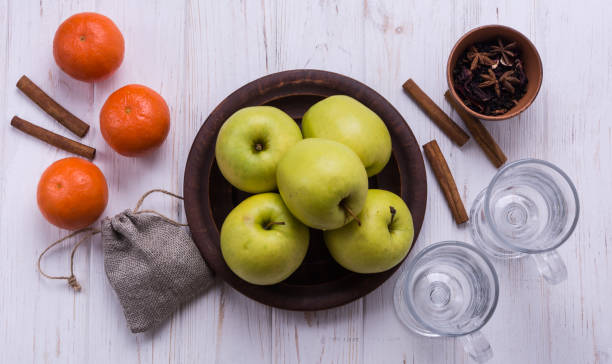 Apple cider vinegar gummies on a wooden table with apples in the background.